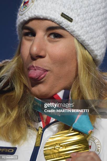 Czech Republic's gold medallist Ester Ledecka sticks her tongue out on the podium during the medal ceremony for the snowboard women's parallel giant...