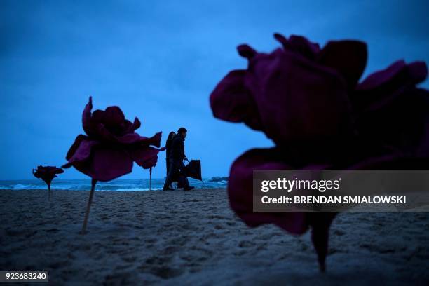 People walk along a art on the beach during the Pyeongchang 2018 Winter Olympic Games in Gangneung, South Korea on February 24, 2018. / AFP PHOTO /...
