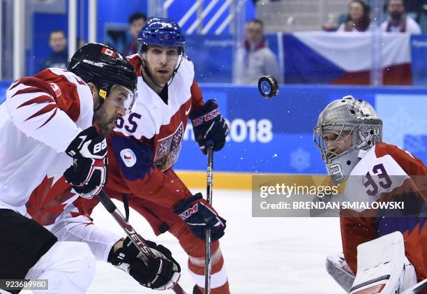 Canada's Andrew Ebbett , Czech Republic's Vojtech Mozik and Czech Republic's Pavel Francouz watch the puck in the men's bronze medal ice hockey match...