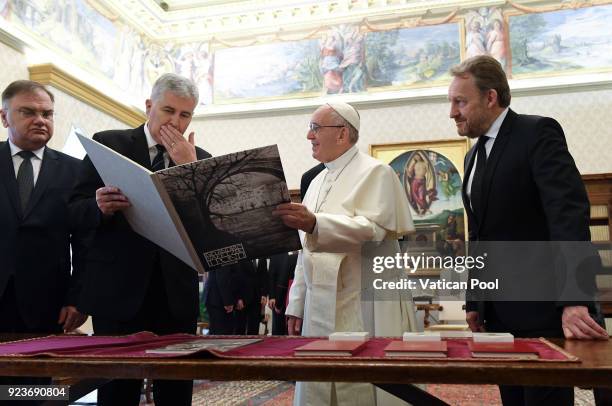 Pope Francis exchanges gifts with the three members of Bosnia's tripartite presidency Mladen Ivanic , Dragan Covic and Bakir Izetbegovic during an...