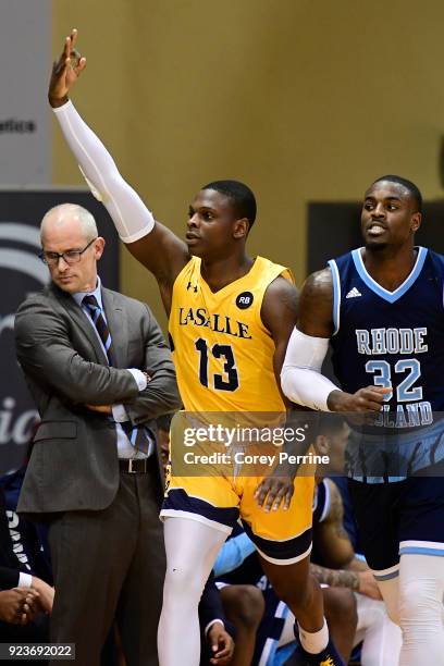 Saul Phiri of the La Salle Explorers signifies a three point basket passing Head coach Dan Hurley of the Rhode Island Rams and next to the Rams'...