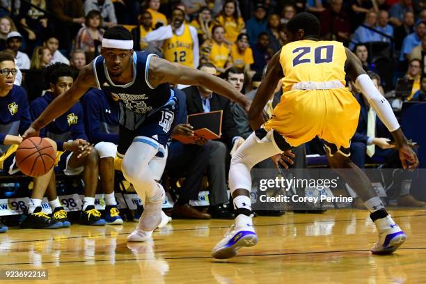 Stanford Robinson of the Rhode Island Rams dribbles against B.J. Johnson of the La Salle Explorers during the first half at Tom Gola Arena on...
