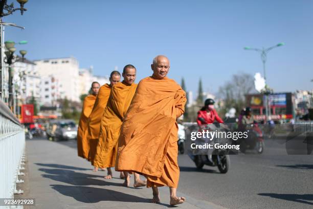 Monks walking down the street collecting alms. Dalat, Vietnam.