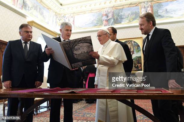 Pope Francis exchanges gifts with the three members of Bosnia's tripartite presidency Mladen Ivanic , Dragan Covic and Bakir Izetbegovic during an...