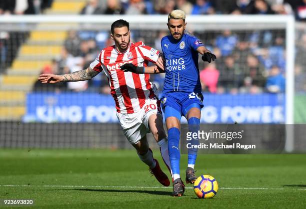 Riyad Mahrez of Leicester City is challenged by Geoff Cameron of Stoke City during the Premier League match between Leicester City and Stoke City at...