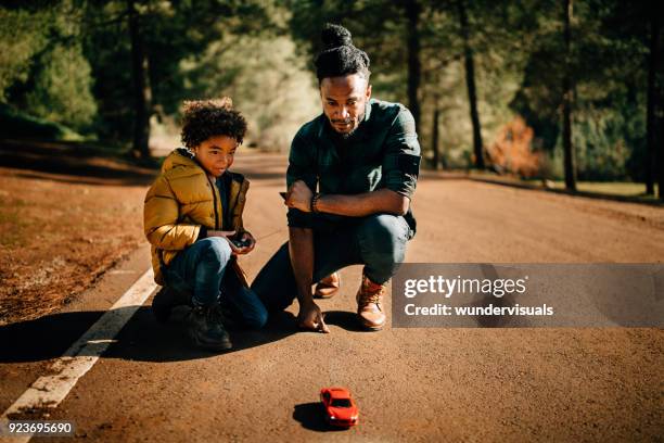 father and son playing with remote controlled car in nature - remote control toy stock pictures, royalty-free photos & images