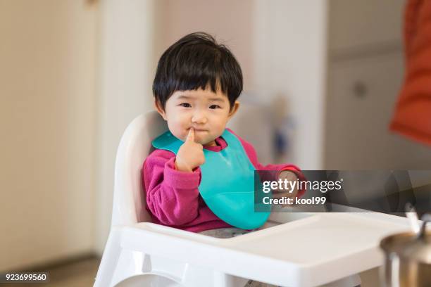 かわいい赤ちゃんの夕食を待っている高椅子に座って - よだれ掛け ストックフォトと画像