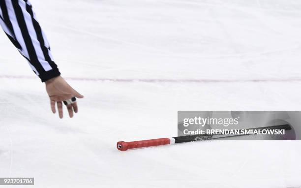 The referee picks up a broken stick in the men's bronze medal ice hockey match between the Czech Republic and Canada during the Pyeongchang 2018...