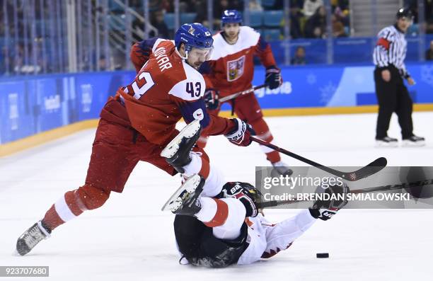 Czech Republic's Jan Kovar pushes past Canada's Brandon Kozun in the men's bronze medal ice hockey match between the Czech Republic and Canada during...