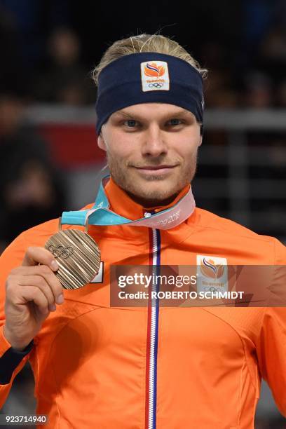 Netherlands' Koen Verweij celebrates his bronze medal on the podium during the men's mass start speed skating event medal ceremony during the...