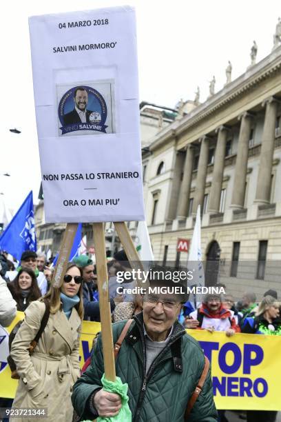 An Italian far-right party Lega Nord's supporter holds a placard reading "Salvini whispered, the stranger will not pass, now or never" and picturing...