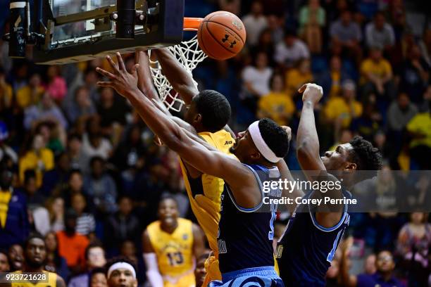 Tony Washington of the La Salle Explorers, Stanford Robinson and Cyril Langevine of the Rhode Island Rams vie for the ball during the second half at...