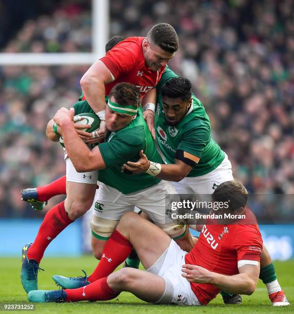 Dublin , Ireland - 24 February 2018; CJ Stander of Ireland is tackled by Hadleigh Parkes and Scott Williams of Wales during the NatWest Six Nations...