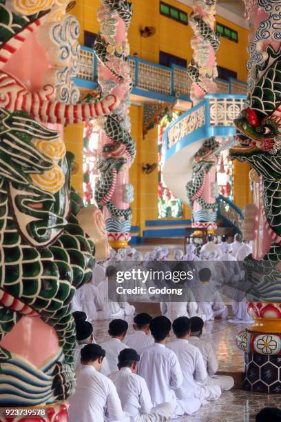 Cao Dai Holy See Temple. Caodaist service under dragon column. Thay Ninh, Vietnam.