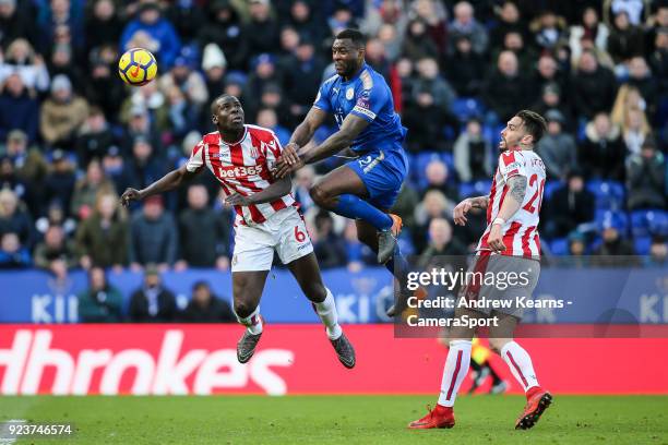 Leicester City's Wes Morgan heads at goal under pressure from Stoke City's Kurt Zouma as Stoke City's Geoff Cameron looks on during the Premier...