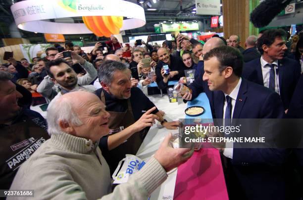 French President Emmanuel Macron speaks to organic potato producers as he visit the 55th International Agriculture Fair at the Porte de Versailles...