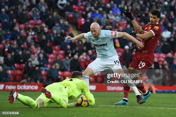 West Ham United's Spanish goalkeeper Adrian saves from Liverpool's English striker Dominic Solanke defended by West Ham United's Welsh defender James...