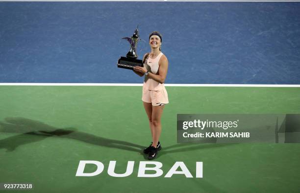 Elina Svitolina of Ukraine poses while holding the champion's trophy after winning the WTA Dubai Duty Free Tennis Championship on February 24, 2018.