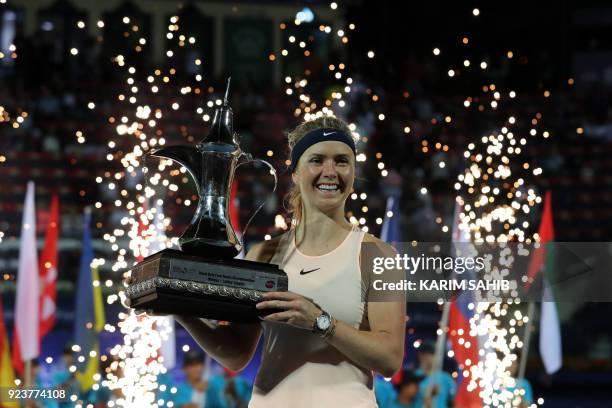 Elina Svitolina of Ukraine poses while holding the champion's trophy after winning the WTA Dubai Duty Free Tennis Championship on February 24, 2018.