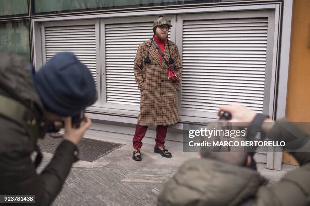 Man poses as he arrives to attend the women's Fall/Winter 2018/2019 collection fashion show by Giorgio Armani in Milan, on February 24, 2018. / AFP...