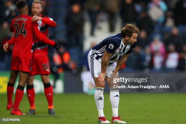 Dejected Craig Dawson of West Bromwich Albion reacts at the final whistle as Huddersfield Town players celebrate their 1-2 win behind during the...