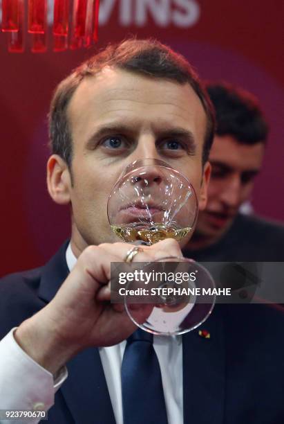 French President Emmanuel Macron tastes white wine as he visits the 55th International Agriculture Fair at the Porte de Versailles exhibition centre...