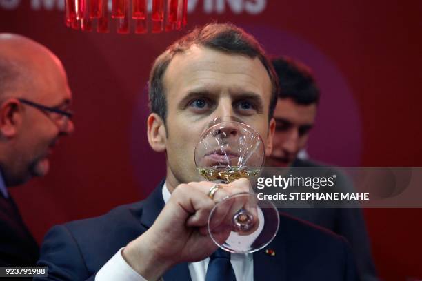 French President Emmanuel Macron tastes white wine as he visits the 55th International Agriculture Fair at the Porte de Versailles exhibition centre...