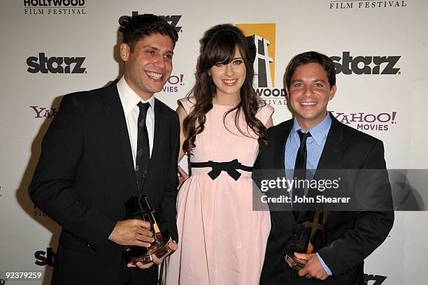 Writers Michael H. Weber and Scott Neustadter pose holding Breakthrough Screenwriter Awards with actress Zooey Deschanel in the press room during the...