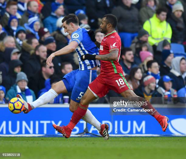 Swansea City's Jordan Ayew vies for possession with Brighton & Hove Albion's Lewis Dunk during the Premier League match between Brighton and Hove...