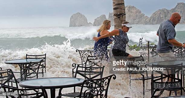 Storm watchers run from the deck at a hotel on Medano Beach as a large wave overtakes their perch as Hurricane Rick approaches Cabo San Lucas October...