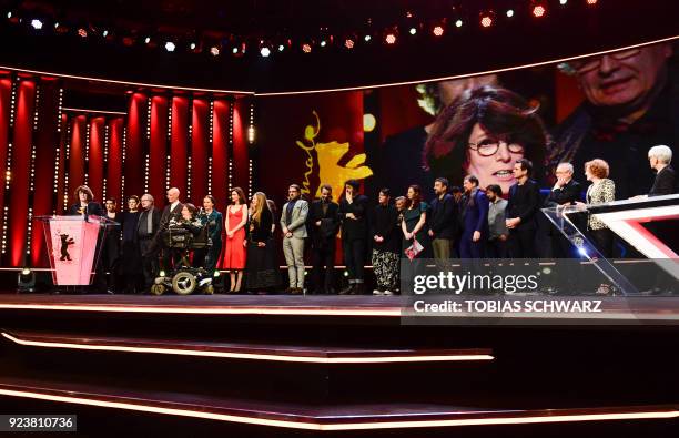 Romanian director Adina Pintilie and her team and the jury pose on stahe after she won the Golden Bear for Best Film award during the awards ceremony...