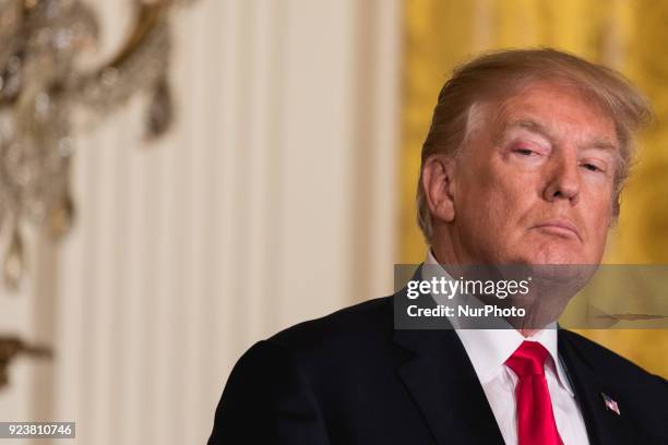 President Donald Trump listens to Prime Minister Malcolm Turnbull of Australia, during their joint press conference, in the East Room of the White...