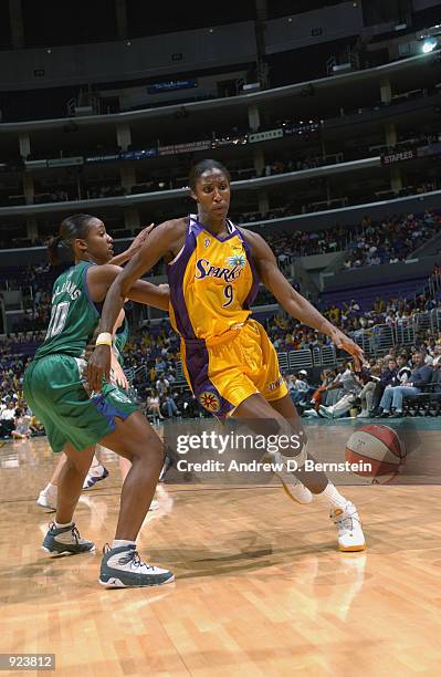 Lisa Leslie of the Los Angeles Sparks moves the ball around Tamika Williams of the Minnesota Lynx in the game on June 21, 2002 at Staples Center in...