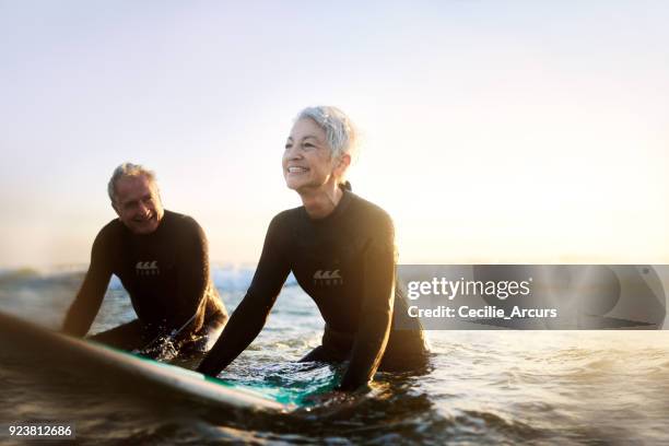 never too old to surf - active seniors beach stock pictures, royalty-free photos & images
