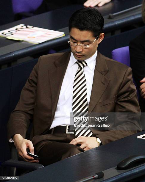 Philipp Roesler, new German Health Minister designate and member of the German Free Democrats political party, types on a mobile phone during the...