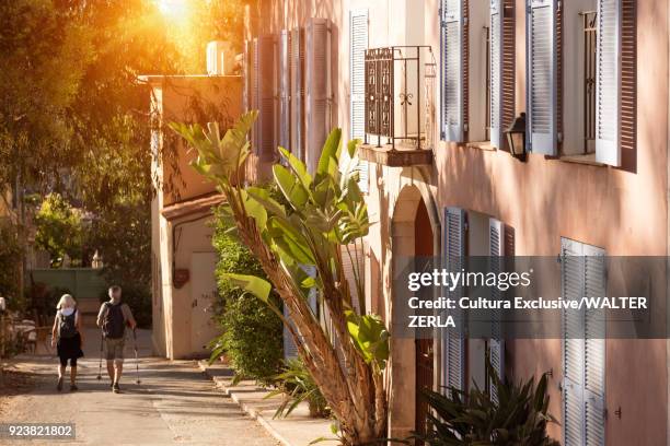 tourist couple strolling on traditional street, porquerolles, provence-alpes-cote dazur - porquerolles photos et images de collection