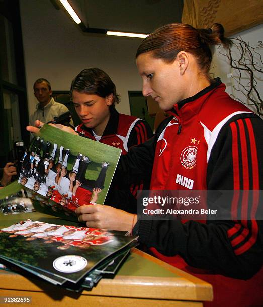 Defenders Sonja Fuss and Annike Krahn of the women's German national soccer team sign autographs during their visit at an elementary school on...