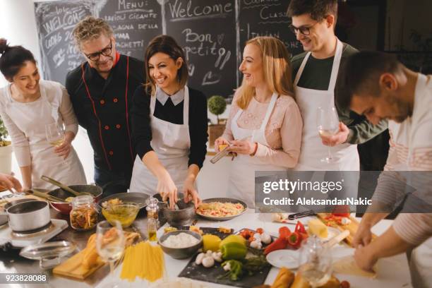 teambuilding in een kookles met een echte chef-kok - italiaanse gerechten stockfoto's en -beelden