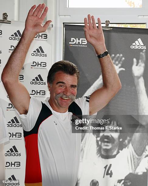 Head coach Heiner Brand presents the new national shirt infront of an old photo of himself during the Team presentation of the German Handball...