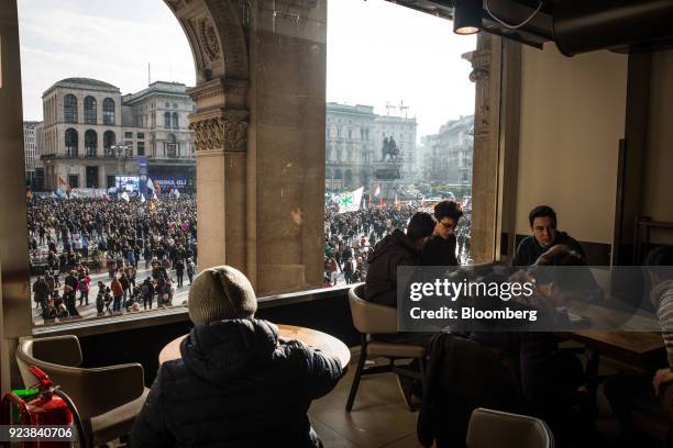 Diners sit in a restaurant as attendees gather during an election campaign rally for The League party at Duomo Square in Milan, Italy, on Saturday,...
