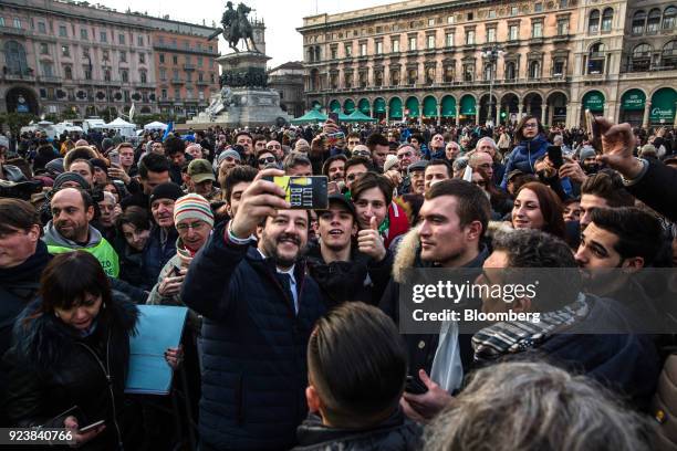 Matteo Salvini, leader of the euroskeptic party League, center left, takes a selfie photograph with attendees after an election campaign rally at...