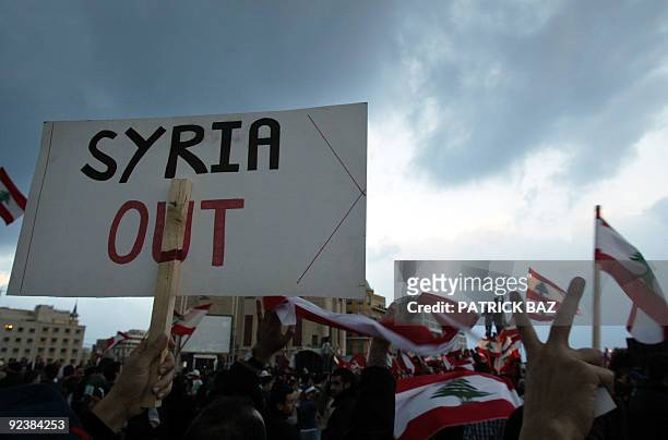 Lebanese protestors hold up national flags and anti-Syria banners during a rally in downtown Beirut 28 February 2005. Thousands of demonstrators...