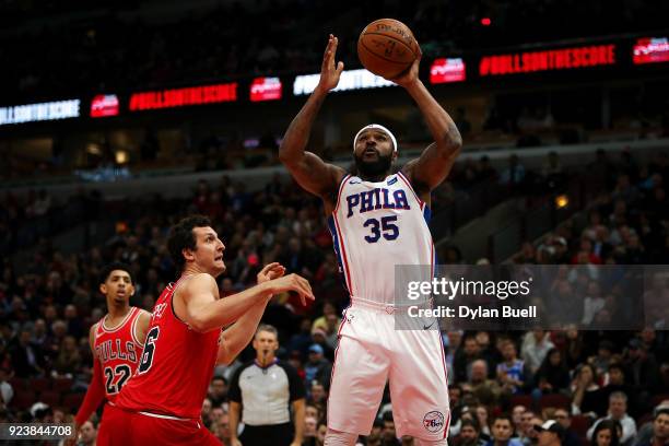 Trevor Booker of the Philadelphia 76ers attempts a shot while being guarded by Paul Zipser of the Chicago Bulls in the second quarter at the United...