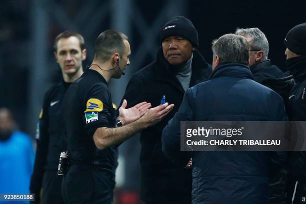 French referee Jerome Brisard intervenes as Guingamp's French coach Antoine Kombouare and Metz's French head coach Frederic Hantz argue during the...
