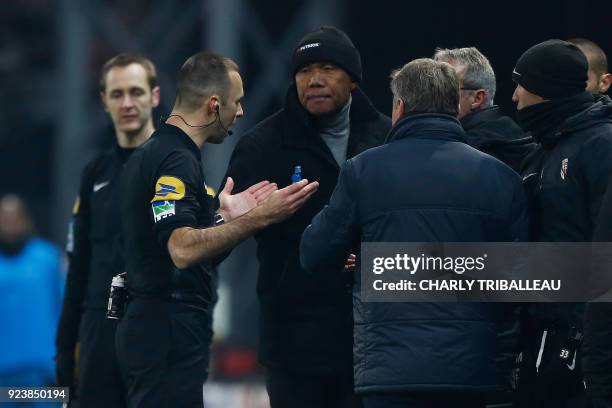 French referee Jerome Brisard intervenes as Guingamp's French coach Antoine Kombouare and Metz's French head coach Frederic Hantz argue during the...