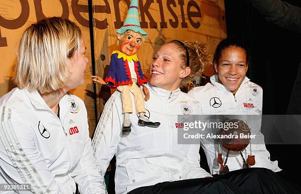 Players Jennifer Zietz , Celia Okoyino da Mbabi and Kim Kulig of the women's German national soccer team pose with marionettes during their visit at...