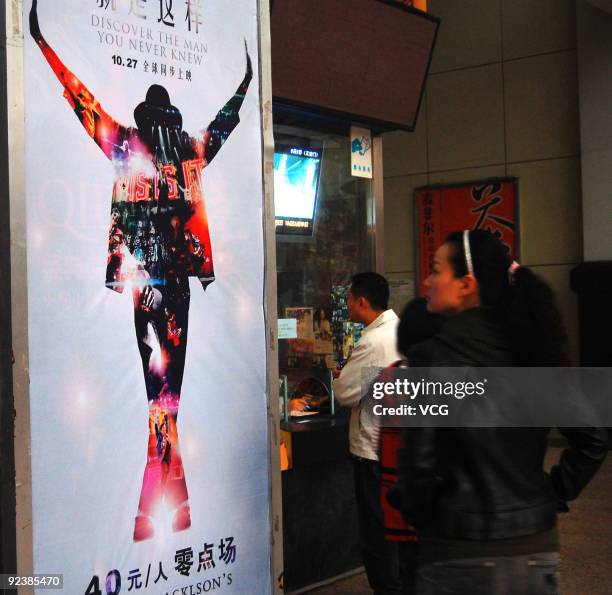 Woman passes a poster promoting the movie "Michael Jackson's,This Is It" on October 27, 2009 in Chongqing of China. The movie uses rehearsal footage...