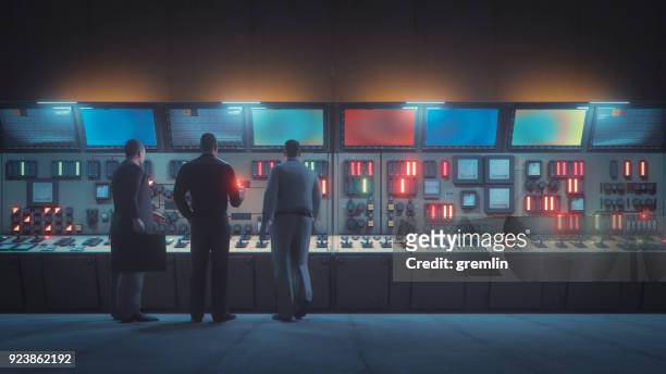 retro ondergrondse controlekamer met mannen voor de console - koude oorlog stockfoto's en -beelden