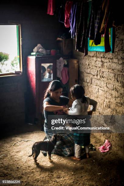 young woman weaving bracelets by window. - guatemala family stock pictures, royalty-free photos & images