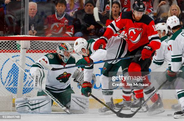 Alex Stalock of the Minnesota Wild in action against Jimmy Hayes of the New Jersey Devils on February 22, 2018 at Prudential Center in Newark, New...